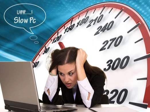 A person looking frustrated while using a slow computer, illustrating the need to fix performance issues