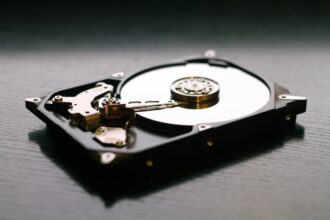 An illustration comparing a fragmented hard drive to a disorganized library. On the left, books are scattered randomly on a shelf, representing fragmented data. On the right, the books are neatly organized, representing a defragmented computer hard drive