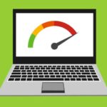 A frustrated person looking at a slow, loading laptop screen with an hourglass icon, representing the need to make the laptop run faster