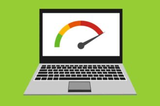 A frustrated person looking at a slow, loading laptop screen with an hourglass icon, representing the need to make the laptop run faster
