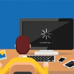 A frustrated person holding their head in their hands while staring at a laptop with a persistent loading symbol on the screen, illustrating the topic of a computer running slowly